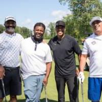 Five alumni smiling for the camera